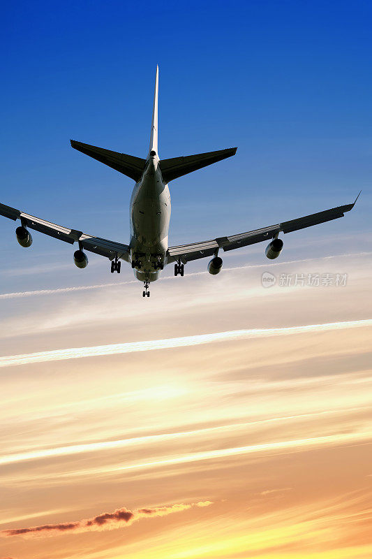 XXL jumbo jet airplane landing at sunset